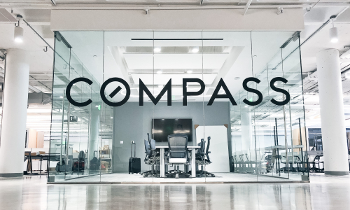 Glass vinyl sign / privacy screen at the San Francisco office of Compass, a modern real estate platform.